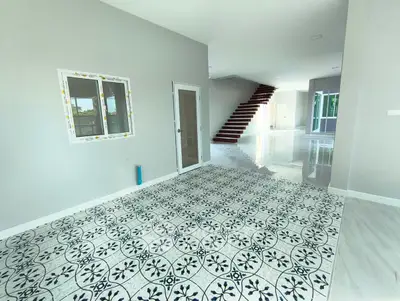 Spacious modern interior with elegant staircase and patterned tile flooring