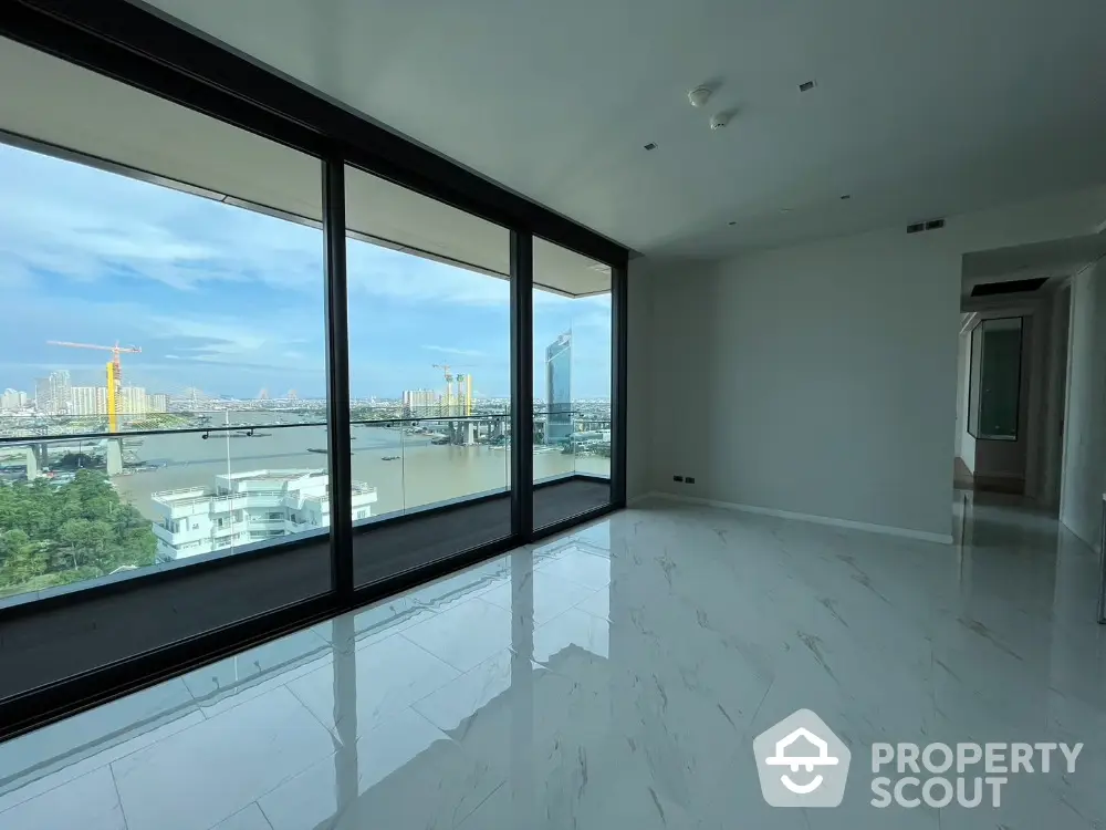 Spacious modern living room with floor-to-ceiling windows offering stunning river and city views.