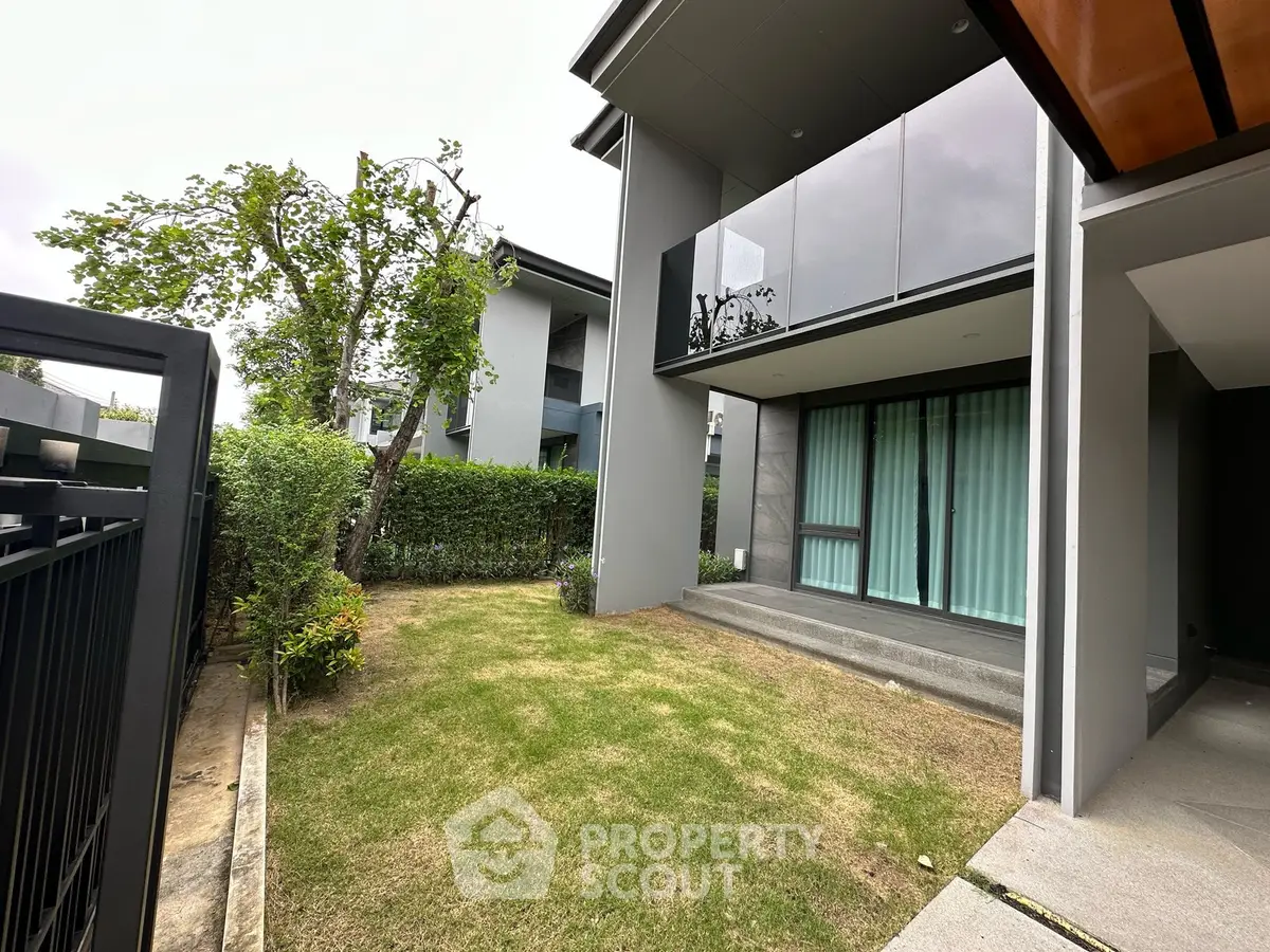 Modern residential building with private garden and sleek balcony design.