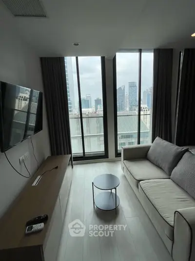 Modern living room with city view, sleek furniture, and large windows in urban apartment.