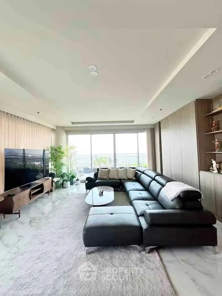Luxurious living room with modern black leather sofa and panoramic window view.