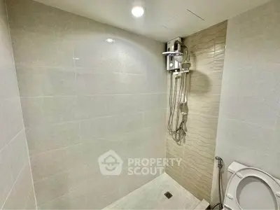 Modern bathroom with sleek shower and tiled walls in a contemporary home.