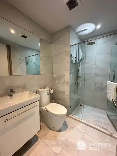 Modern bathroom with sleek design, glass shower enclosure, and elegant fixtures.