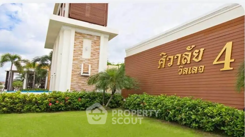 Modern residential building entrance with lush landscaping and clear signage.