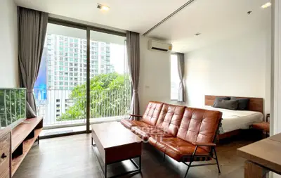 Modern studio apartment with balcony and city view, featuring stylish furniture and natural light.