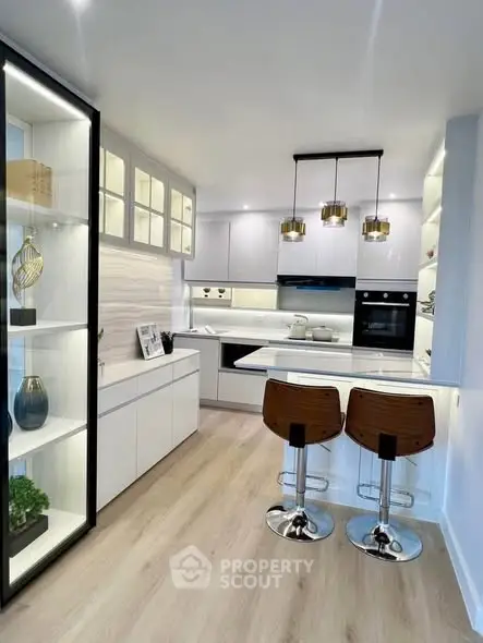 Modern kitchen with sleek white cabinets and stylish bar stools
