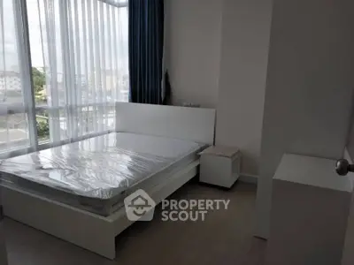 Modern bedroom with large windows and natural light in a stylish apartment.