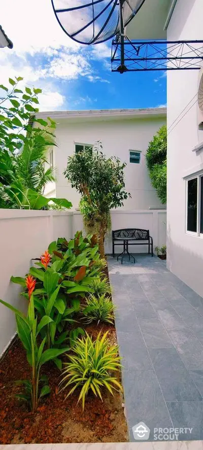 Charming garden area with lush greenery and modern patio, perfect for relaxation and outdoor enjoyment.