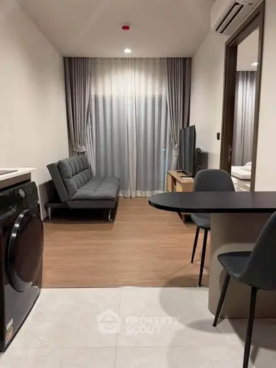 Modern living room with sleek furniture and washing machine, ideal for urban living.