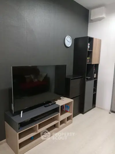 Modern living room with sleek TV setup and stylish shelving unit.