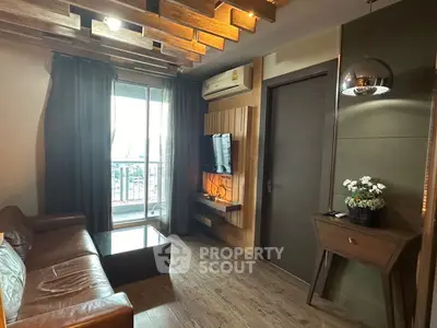 Stylish living room with modern decor and balcony access, featuring a cozy leather sofa and wooden accents.