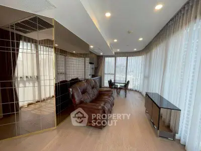 Spacious living room with leather sofa and floor-to-ceiling windows