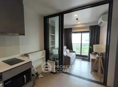 Modern apartment with open layout, featuring a cozy living room and sleek kitchen area.