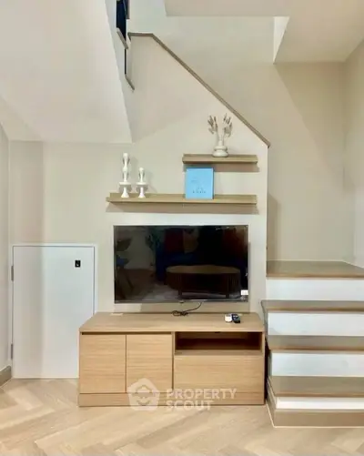 Modern living room with stylish staircase and sleek TV unit