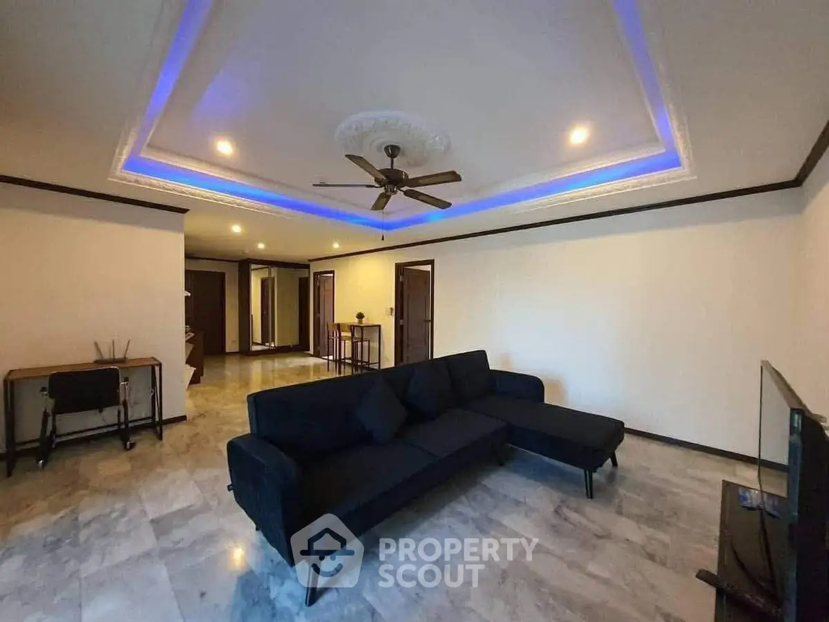 Spacious living room with modern ceiling design and cozy sectional sofa.