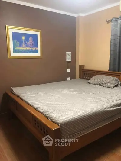 Cozy bedroom with wooden bed frame and elegant wall art, perfect for relaxation.