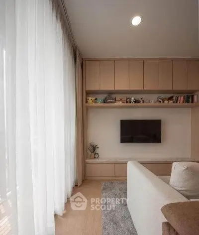 Modern living room with built-in shelves and wall-mounted TV, featuring elegant curtains and cozy seating.