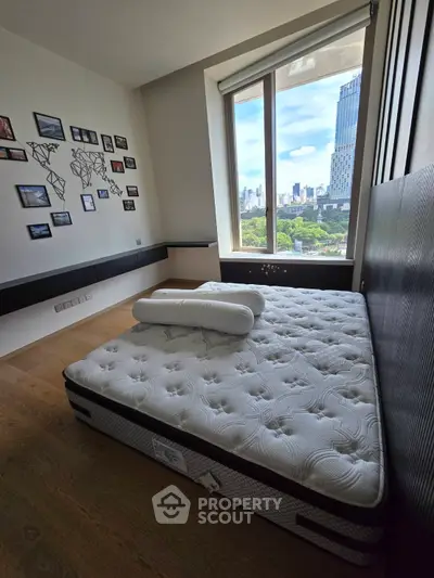Modern bedroom with large window offering stunning cityscape view