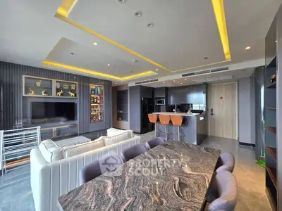 Luxurious open-plan living room with modern kitchen and elegant dining area, featuring sleek design and ambient lighting.