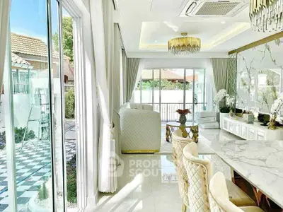 Luxurious living room with elegant decor and large windows opening to a stylish patio.