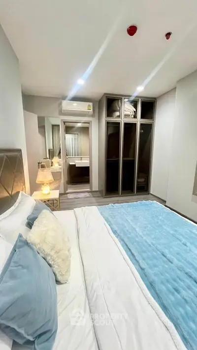 Modern bedroom with cozy bedding and built-in wardrobe in a stylish apartment.