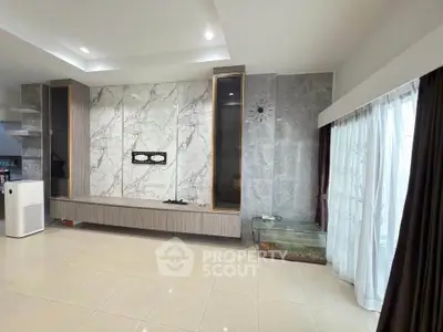 Spacious modern living room with marble accent wall and large windows