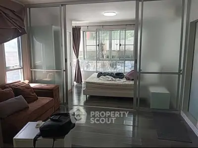Modern studio apartment with glass partitions and natural light