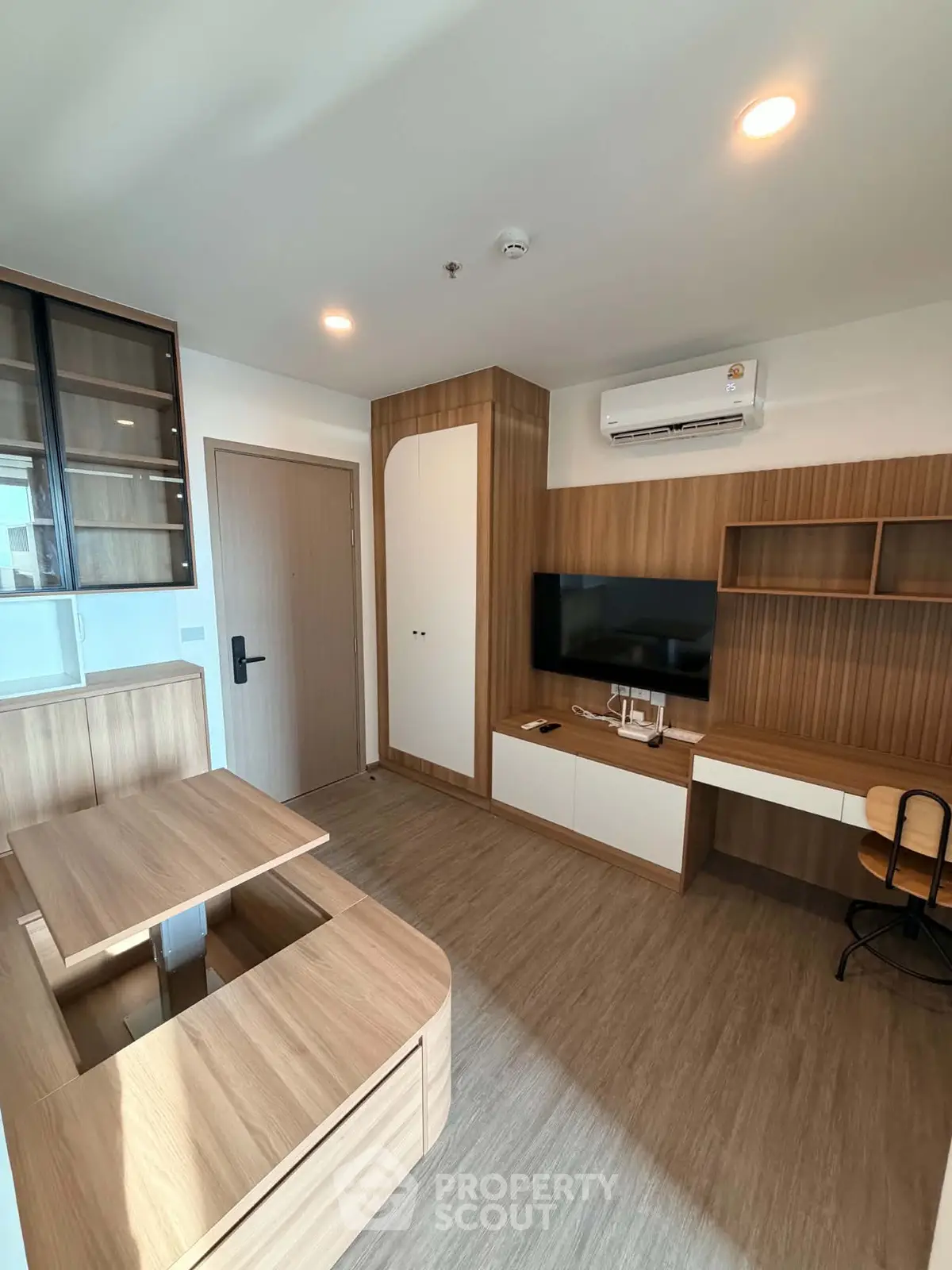 Modern living room with wooden furniture and wall-mounted TV in a stylish apartment.