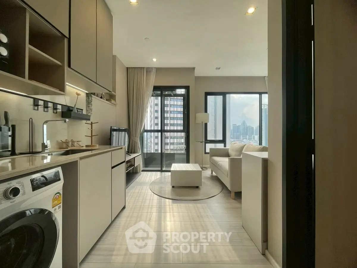 Modern apartment interior with open kitchen and living room, featuring city view and stylish decor.