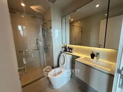 Modern bathroom with glass shower and sleek vanity in luxury apartment