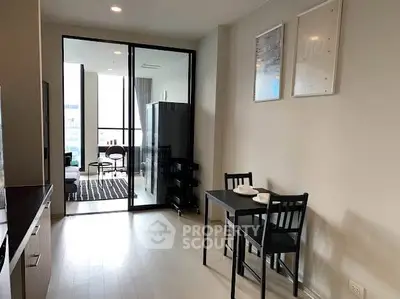 Modern apartment interior with open layout, featuring a compact dining area and stylish living room.