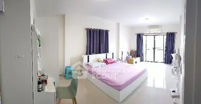 Spacious bedroom with modern decor and natural light, featuring a large bed and stylish furnishings.