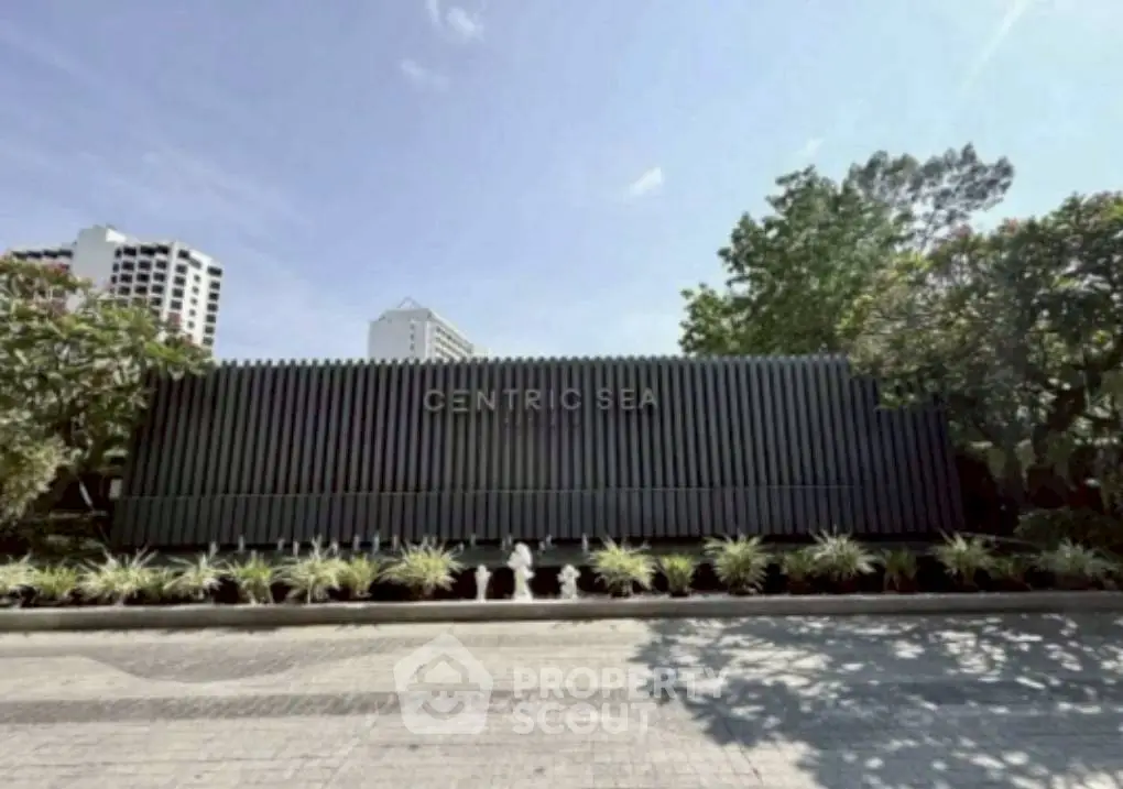 Modern building exterior with sleek design and lush landscaping at Centric Sea.