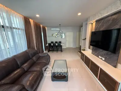Spacious modern living room with leather sofa and wall-mounted TV