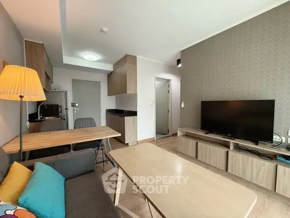 Modern living room with stylish furniture and wall-mounted TV in a cozy apartment.