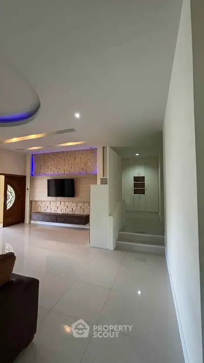 Spacious modern living room with sleek design and built-in TV unit, perfect for stylish urban living.