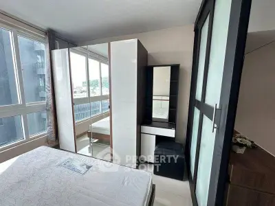 Modern bedroom with large windows and sleek furniture in a high-rise apartment.