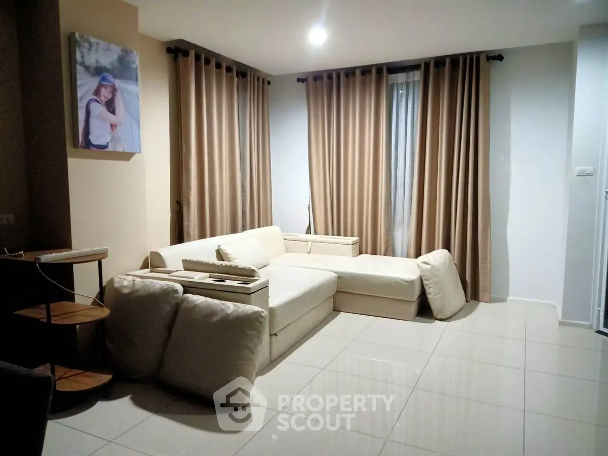 Cozy living room with modern beige sofa and elegant curtains, perfect for relaxation and entertaining.