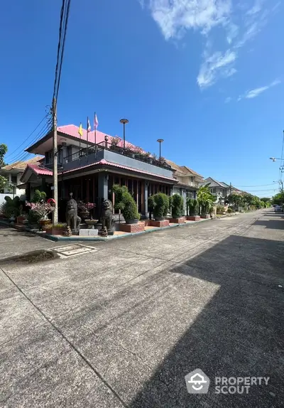 Charming residential street with unique architecture and lush greenery under a clear blue sky.