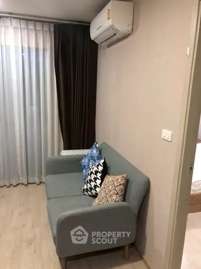 Cozy living room with modern sofa and air conditioning, perfect for relaxation.