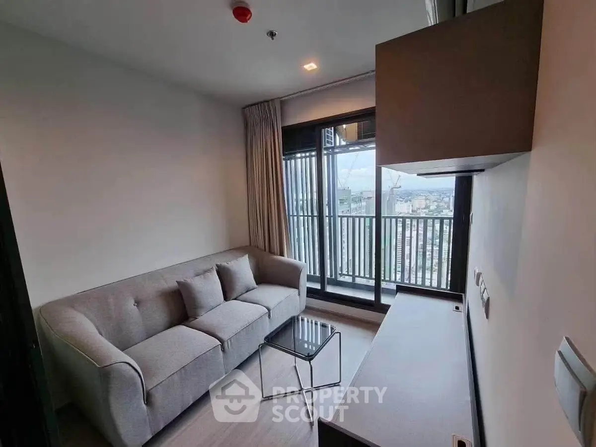 Modern living room with cozy sofa and city view balcony in a stylish apartment.