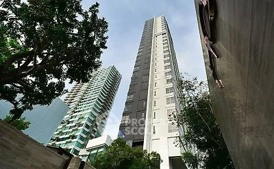 Stunning high-rise building with modern architecture and lush greenery in urban setting.