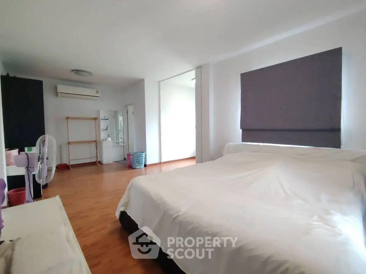 Spacious bedroom with wooden flooring and modern decor