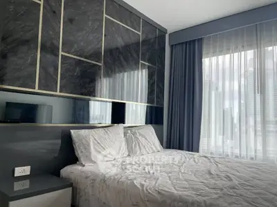 Luxurious bedroom with modern design and city view through large windows.