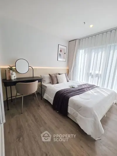 Modern bedroom with stylish decor and natural light, featuring a cozy bed and elegant workspace.