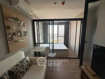 Modern studio apartment with glass partition, cozy living area, and city view.