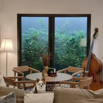 Charming living room with elegant decor and garden view, featuring a cozy seating area and stylish musical instrument.