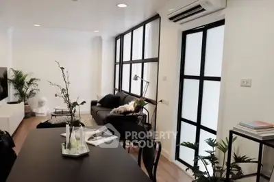 Stylish modern living room with sleek furniture and large windows in a contemporary apartment.
