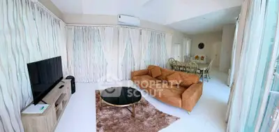 Spacious living room with modern decor and natural light, featuring a cozy sofa and dining area.