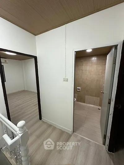 Spacious hallway with access to bathroom and bedroom, featuring modern flooring.